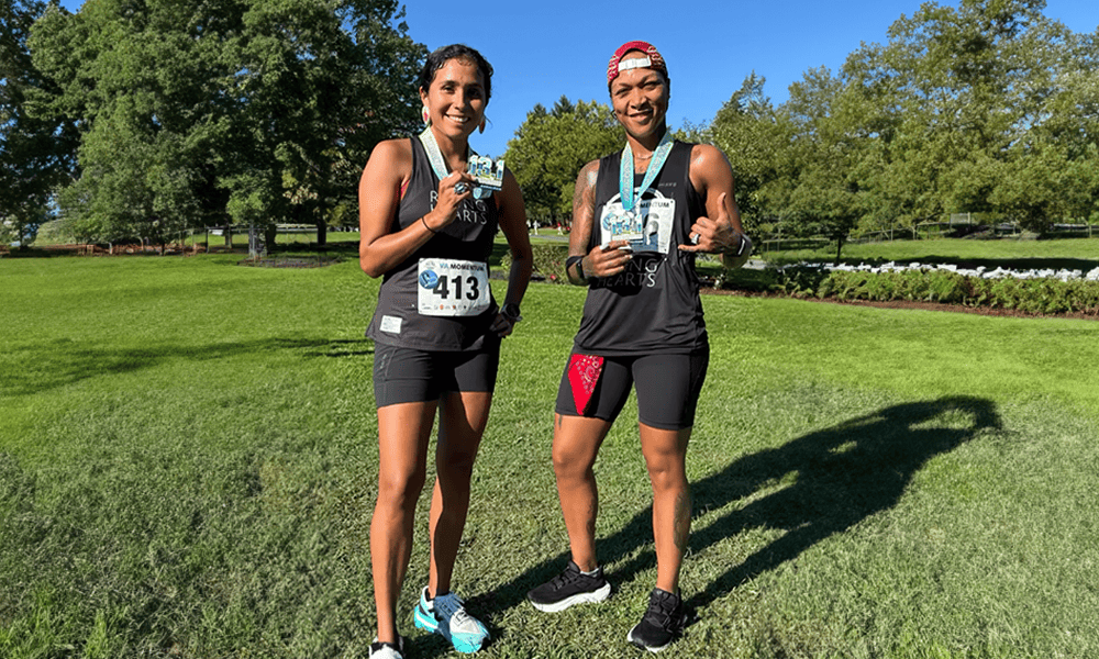 Jordan Daniel and Kali Reis stand in marathon running attire smiling.